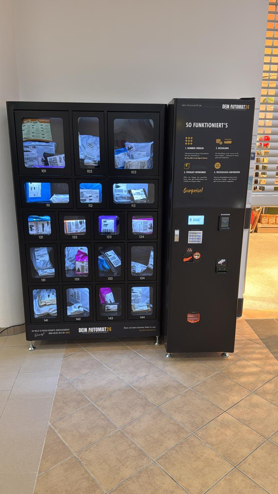 Schwarzer Fächerautomat mit bunten Packs und separater Bedieneinheit.